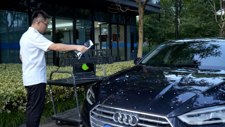 Persona escaneando un automóvil utilizando el escáner iReal 2E