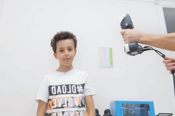 Persona utilizando el escáner iReal 2E para escanear un modelo humano